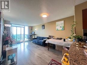 Mississauga (Central Erin Mills) condo for rent - A living room with a blue sofa and a dining table with chairs.