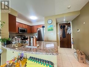Mississauga (Central Erin Mills) condo for rent - A kitchen with granite countertops and a refrigerator.