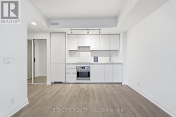 Toronto (Thorncliffe Park) condo for rent - A white kitchen with a stove top oven and cabinets.
