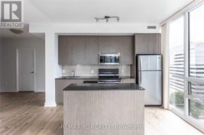 Toronto (Willowdale East) condo for rent - A modern kitchen with a wooden island and stainless steel appliances.