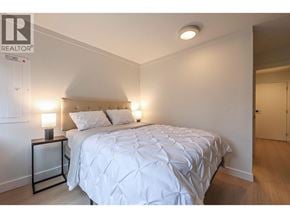 Vancouver apartment for rent - A bedroom with a bed, nightstand, and lamp.