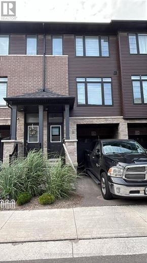Brantford townhouse for rent - A black truck is parked in front of a brown building.