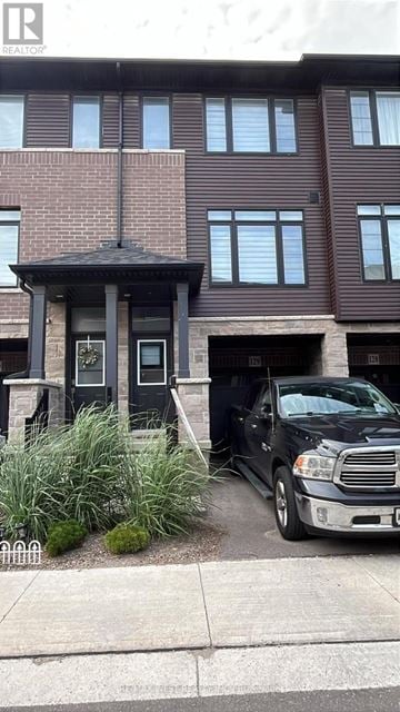 Brantford townhouse for rent - A black truck is parked in front of a brown building.