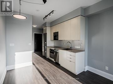 Toronto (Mount Pleasant East) condo for rent - A modern kitchen with white cabinets and a wooden floor.