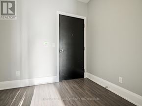 Toronto (Mount Pleasant East) condo for rent - A black door is in the middle of a room with a wooden floor.