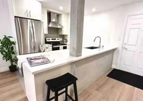 White Rock apartment for rent - A kitchen with a white countertop and a black stool.