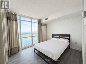 Toronto (Waterfront Communities) condo for rent - A bedroom with a large bed and a view of the water.