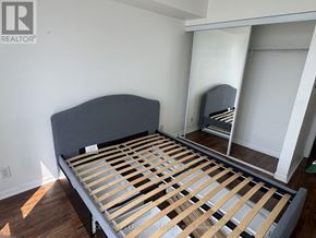 Toronto (Kensington-Chinatown) condo for rent - A bed with wooden slats is in a room with white walls.