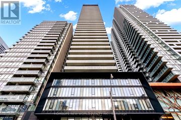 Toronto (Church-Yonge Corridor) condo for rent - A tall building with a balcony in the foreground and other buildings in the background.