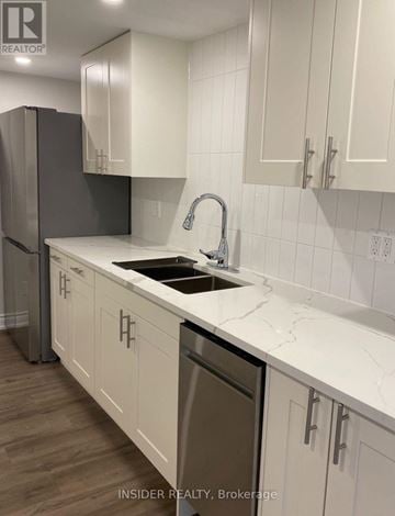 Hamilton (Buchanan) apartment for rent - A kitchen with white cabinets and a marble countertop.