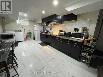 Toronto (Newtonbrook West) apartment for rent - A kitchen with black cabinets and white marble flooring.
