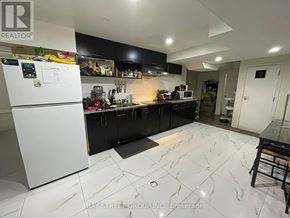Toronto (Newtonbrook West) apartment for rent - A kitchen with a white fridge and black cabinets.