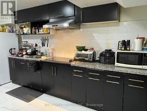 Toronto (Newtonbrook West) apartment for rent - A kitchen with black cabinets and a white fridge.