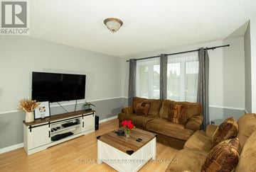 Port Colborne (Main Street) apartment for rent - A living room with a brown couch and a flat screen TV.