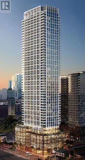 Toronto (Church-Yonge Corridor) condo for rent - A tall glass building stands in the middle of a cityscape.