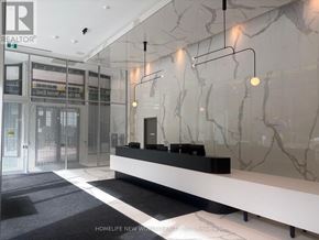 Toronto (Church-Yonge Corridor) condo for rent - A reception area with a marble wall and a black and white carpet.