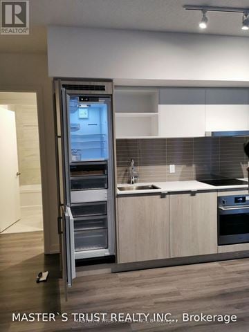 Toronto (Waterfront Communities) condo for rent - A modern kitchen with a refrigerator and a sink.