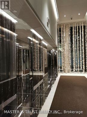 Toronto (Waterfront Communities) condo for rent - A hallway with a brown carpet and a curtain with lights behind it.