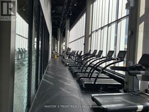 Toronto (Waterfront Communities) condo for rent - A gym with treadmills and a glass wall.
