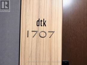 Kitchener condo for rent - A wooden door with the initials "dtk" and the number "1707" engraved on it.