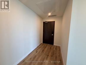 Kitchener condo for rent - A room with a wooden floor and a brown door.
