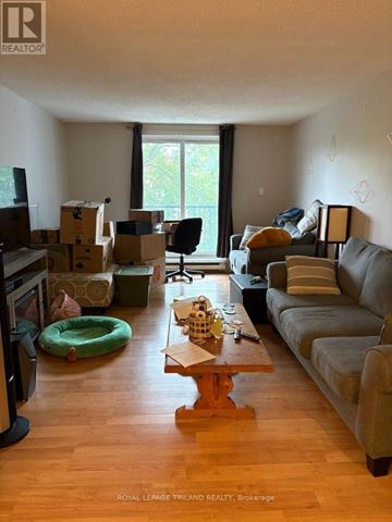 London East (East B) condo for rent - A living room with a grey couch and a wooden coffee table.