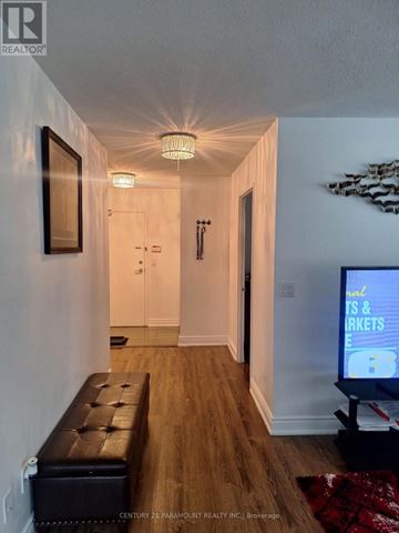 Mississauga (City Centre) condo for rent - A hallway with a bench and a television on the right side.