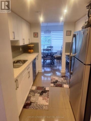Mississauga (City Centre) condo for rent - A kitchen with white cabinets and a refrigerator.
