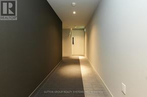 Mississauga (City Centre) condo for rent - A hallway with a logo on the wall and a door at the end.