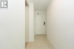 Mississauga (City Centre) condo for rent - A hallway with a door on the right and a wall on the left.