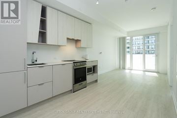 Mississauga (City Centre) condo for rent - A modern kitchen with white cabinets and a stainless steel oven.