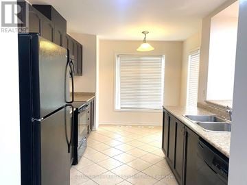 Milton (Wi Willmott) townhouse for rent - A kitchen with a black fridge and a window with blinds.