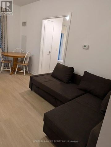 Toronto (Mount Pleasant West) condo for rent - A living room with a brown couch and a dining table.
