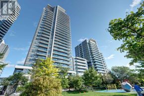 Markham (Grandview) condo for rent - A modern residential building with a glass facade stands tall among other buildings and greenery.