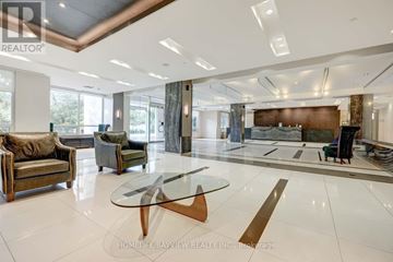 Markham (Grandview) condo for rent - A spacious living room with a glass table and leather chairs.