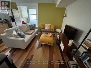 Toronto (Alderwood) apartment for rent - A living room with a white couch and a yellow ottoman.