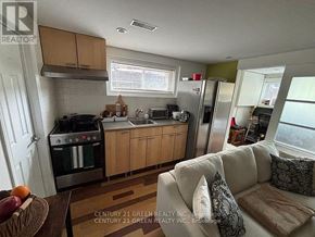 Toronto (Alderwood) apartment for rent - A kitchen with a couch and a table in front of it.