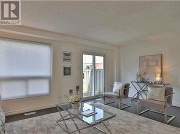 Kitchener townhouse for rent - A living room with a glass coffee table and a painting on the wall.