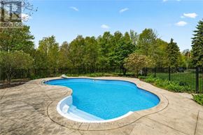 Burlington apartment for rent - A swimming pool surrounded by a concrete patio and a black fence.