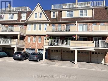 Mississauga (Cooksville) townhouse for rent - A building with balconies and garages in front of it.