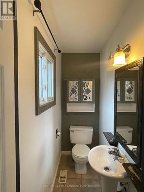 London North (North I) apartment for rent - A bathroom with a toilet, sink, and mirror.
