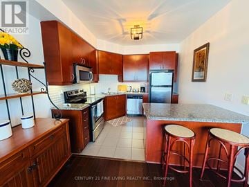 Mississauga (Port Credit) condo for rent - A kitchen with wooden cabinets and a bar area.