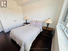 Mississauga (Port Credit) condo for rent - A bedroom with a bed, two lamps, and a wooden nightstand.