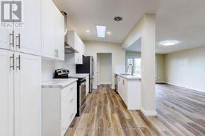 Hamilton (Lawfield) apartment for rent - A kitchen with white cabinets and a wooden floor.