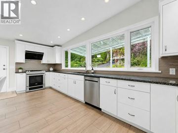 West Vancouver apartment for rent - A modern kitchen with white cabinets and a large window.