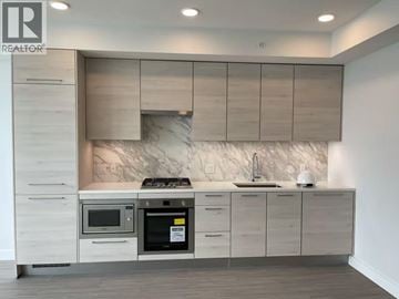 Burnaby apartment for rent - A modern kitchen with a marble backsplash and stainless steel appliances.