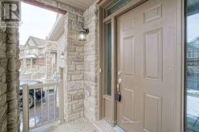 Hamilton (Stoney Creek Mountain) townhouse for rent - A brown door is on the right side of a stone pillar.