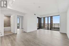 Toronto (Leaside) condo for rent - A spacious room with a view of the city through large windows.