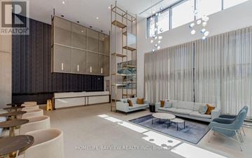 Mississauga (Creditview) condo for rent - A modern living room with a white sofa and a glass partition wall.