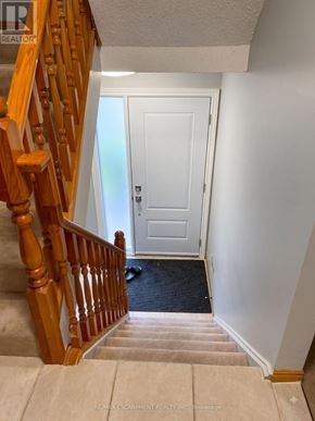 Hamilton (Eastmount) apartment for rent - A hallway with a staircase leading to a door.